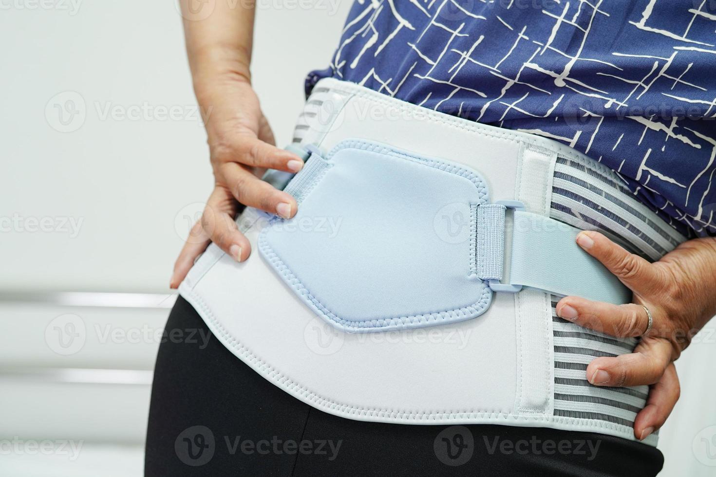Asian senior wearing elastic support belt can help reduce back pain