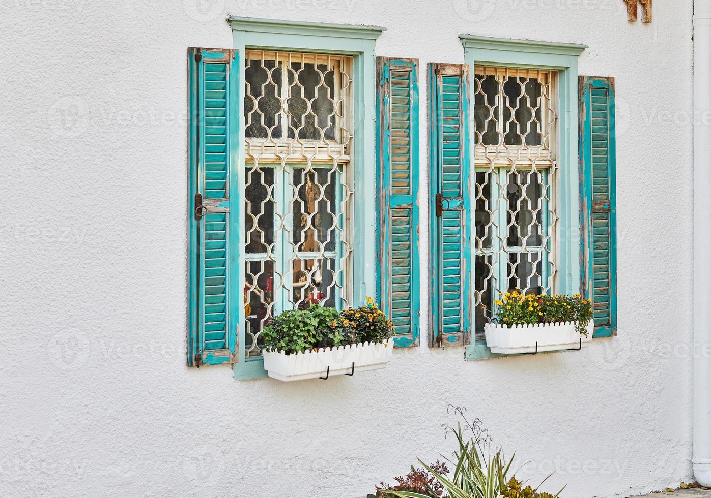 Wooden windows and shutters painted blue in house at sunset photo