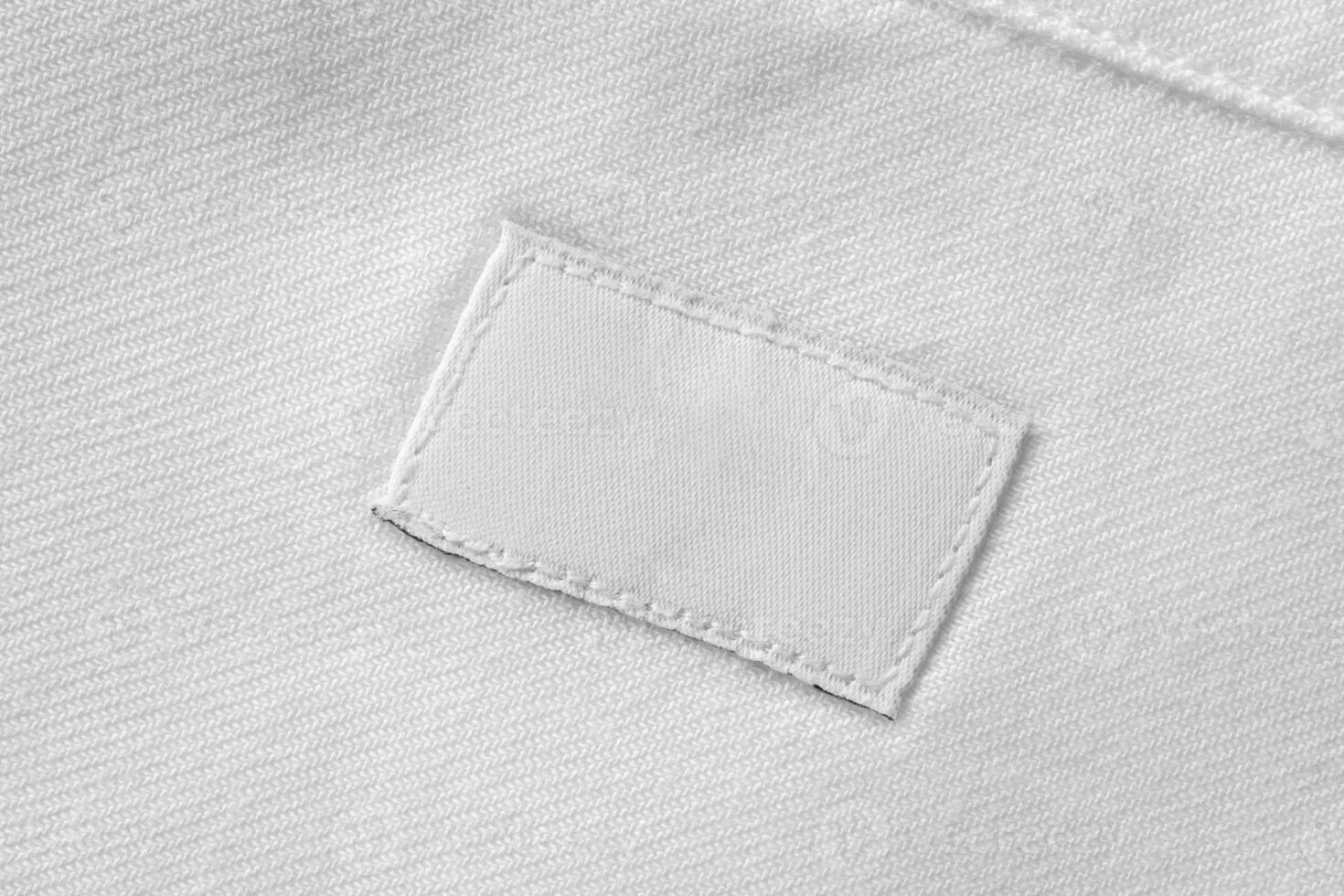 White blank laundry care clothes label on cotton shirt background