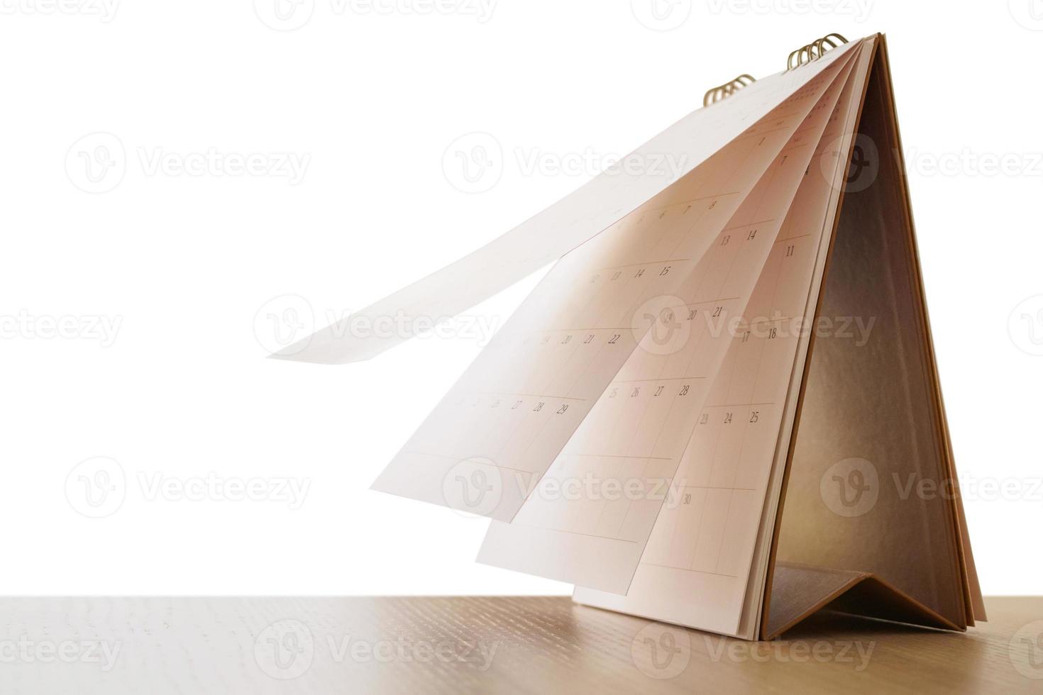 Calendar page flipping sheet on wood table isolated on white background business schedule planning appointment meeting concept photo