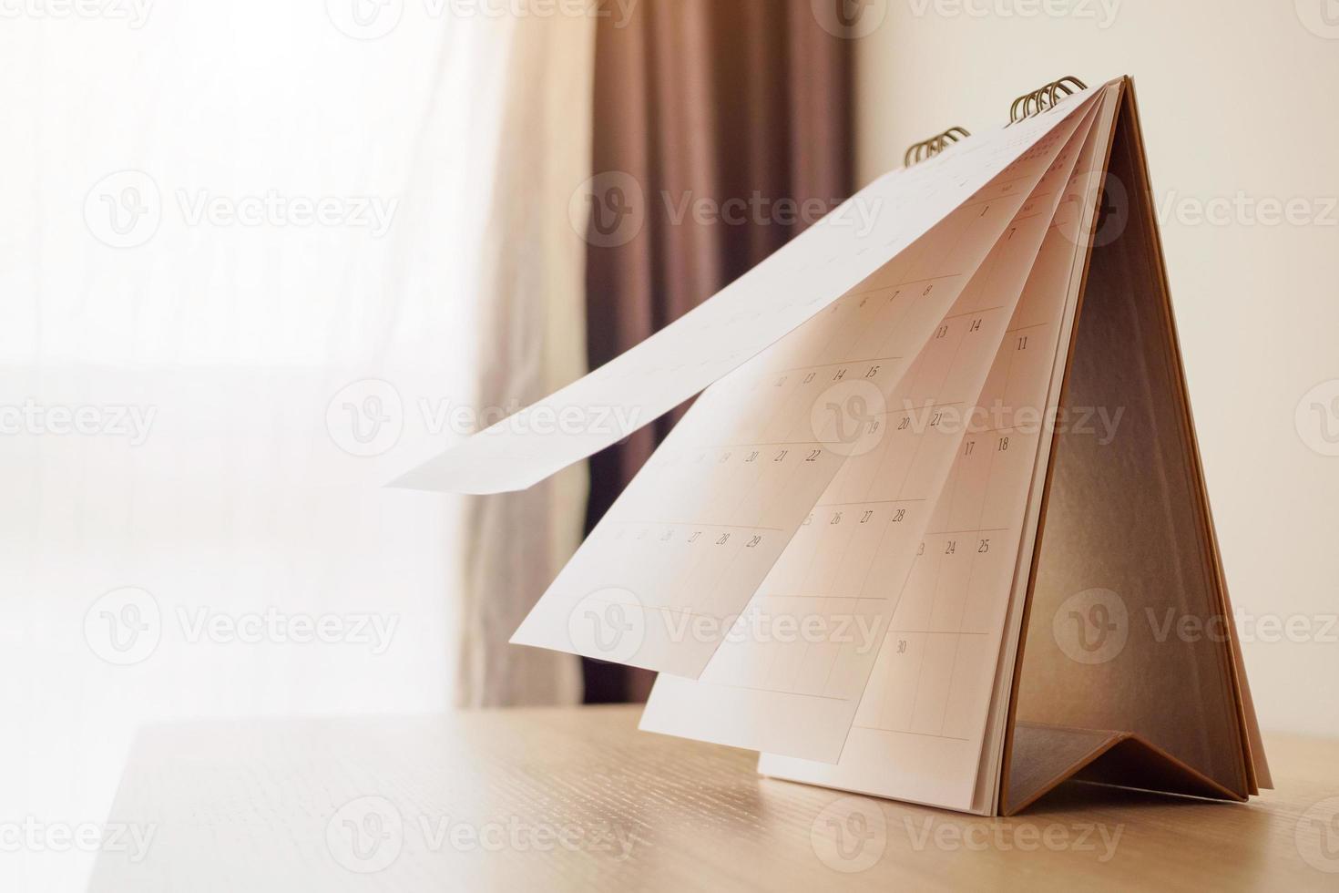 Calendar page flipping sheet on wood table background business schedule planning appointment meeting concept photo