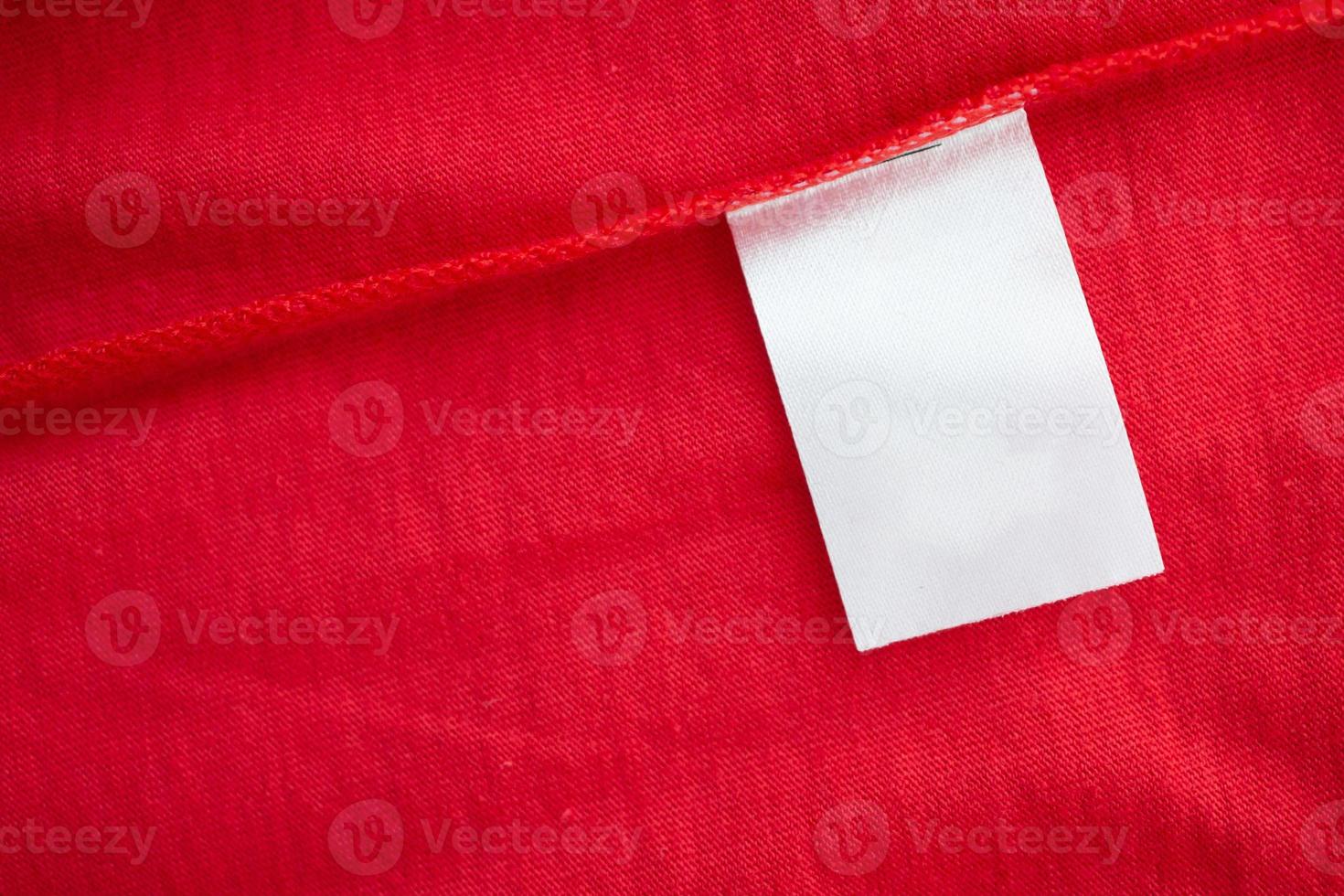 White laundry care washing instructions clothes label on red cotton shirt photo