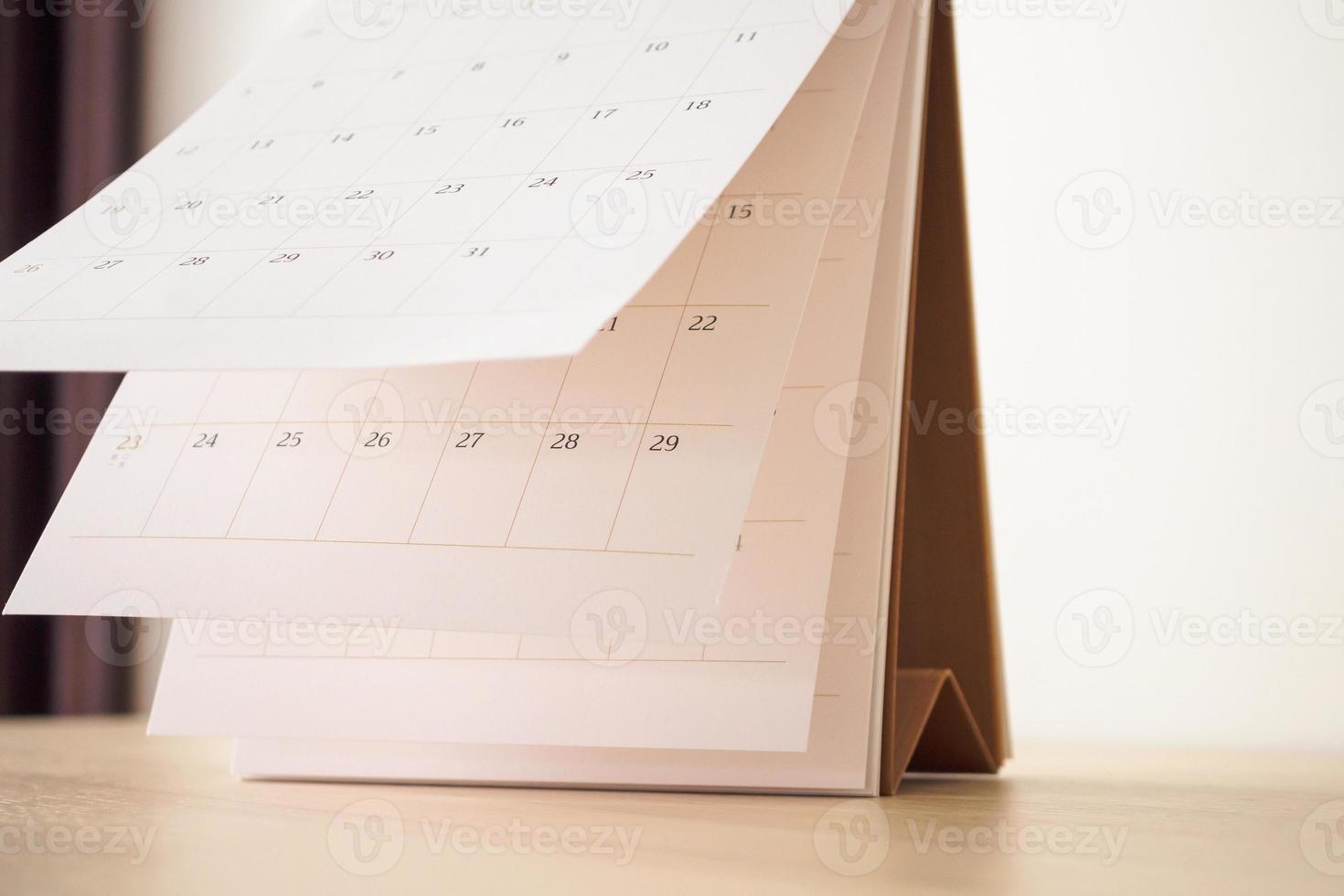 Calendar page flipping sheet on wood table background business schedule planning appointment meeting concept photo