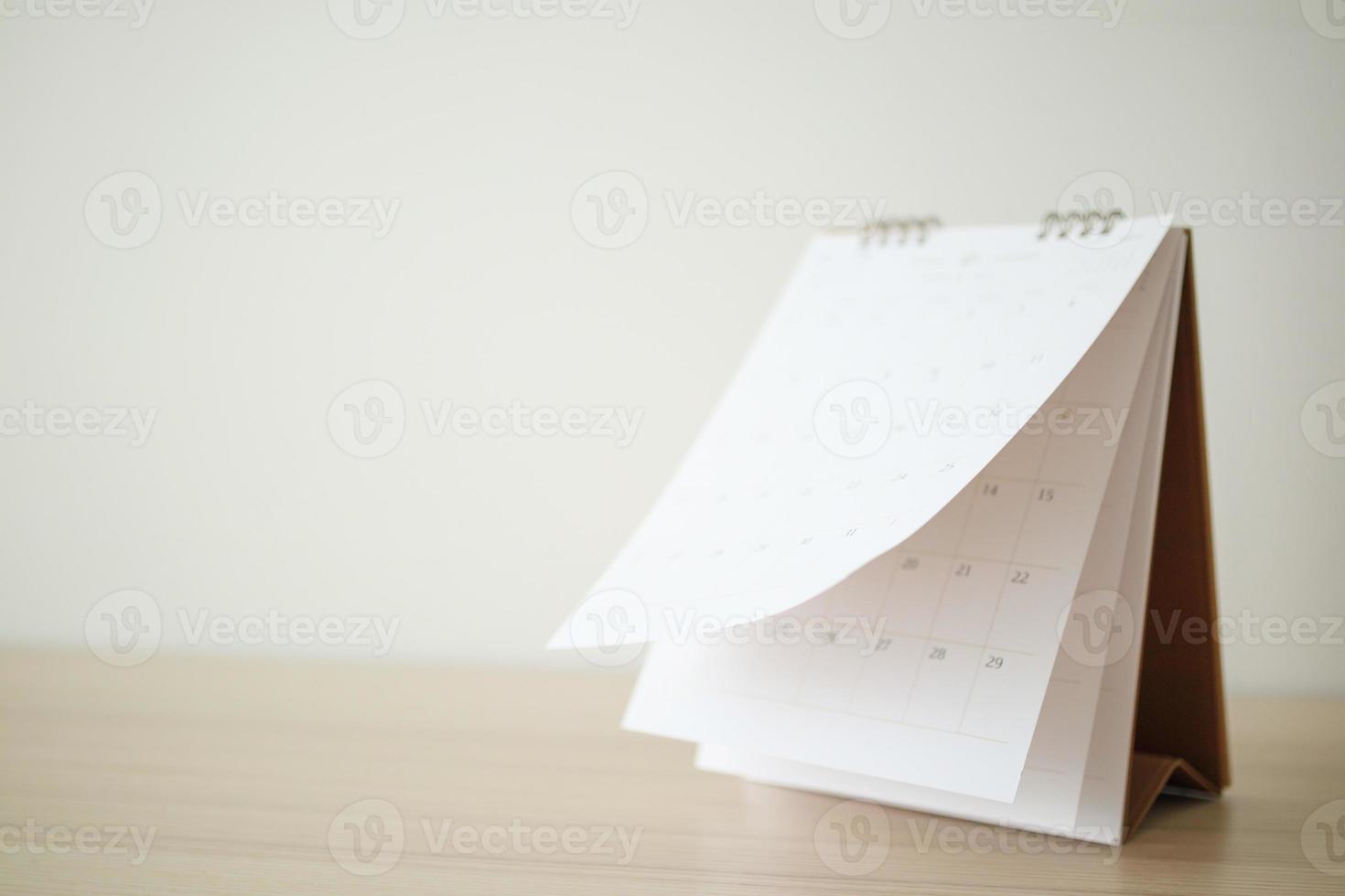Blur Calendar page flipping sheet on wood table background business schedule planning appointment meeting concept photo