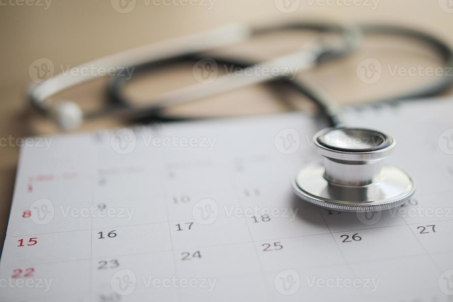 Stethoscope with calendar page date on wood table background doctor appointment medical concept photo