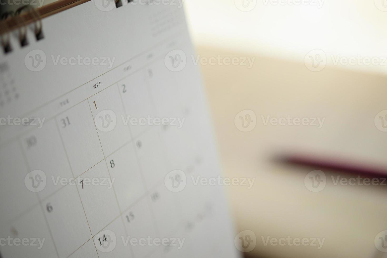 página del calendario de cerca en el fondo de la mesa de madera con bolígrafo y cuaderno concepto de reunión de cita de planificación empresarial foto