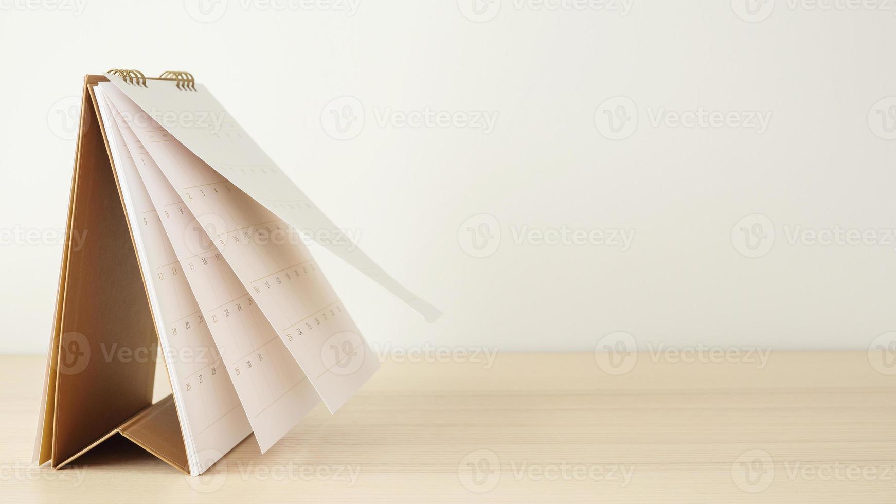 Calendar page flipping sheet on wood table background business schedule planning appointment meeting concept photo