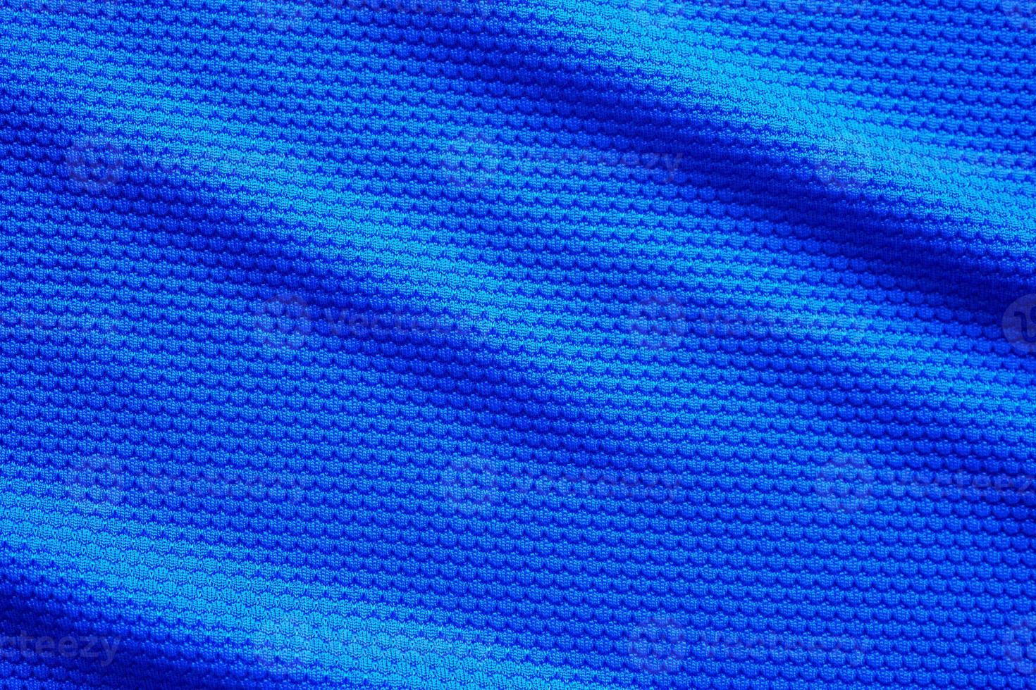 Blue football jersey clothing fabric texture sports wear background, close up top view photo