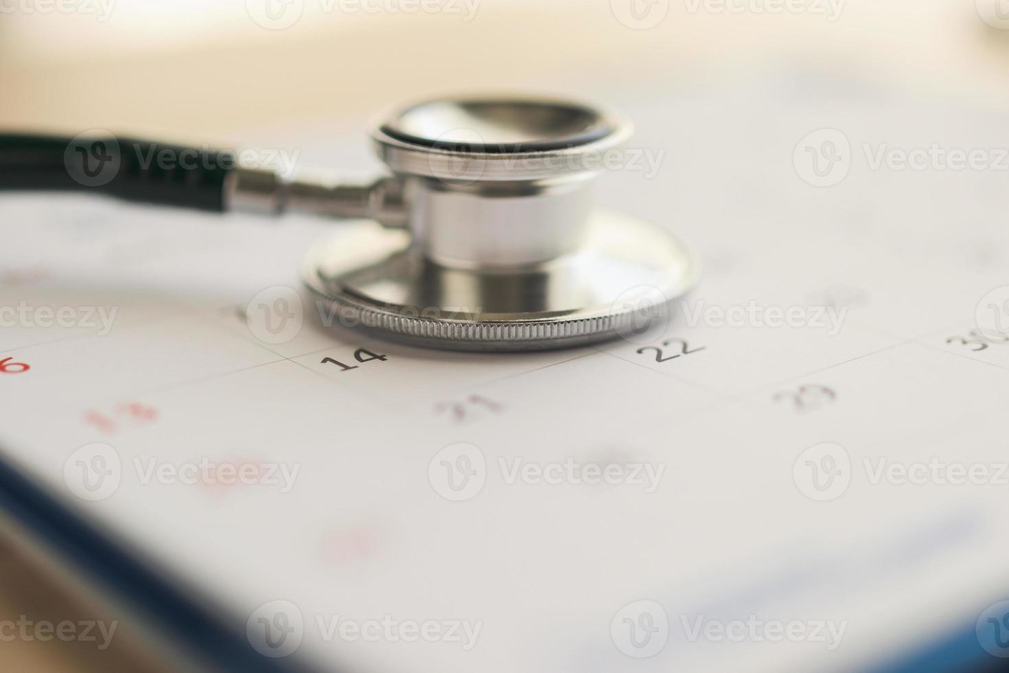 Stethoscope with calendar page date on wood table background doctor appointment medical concept photo