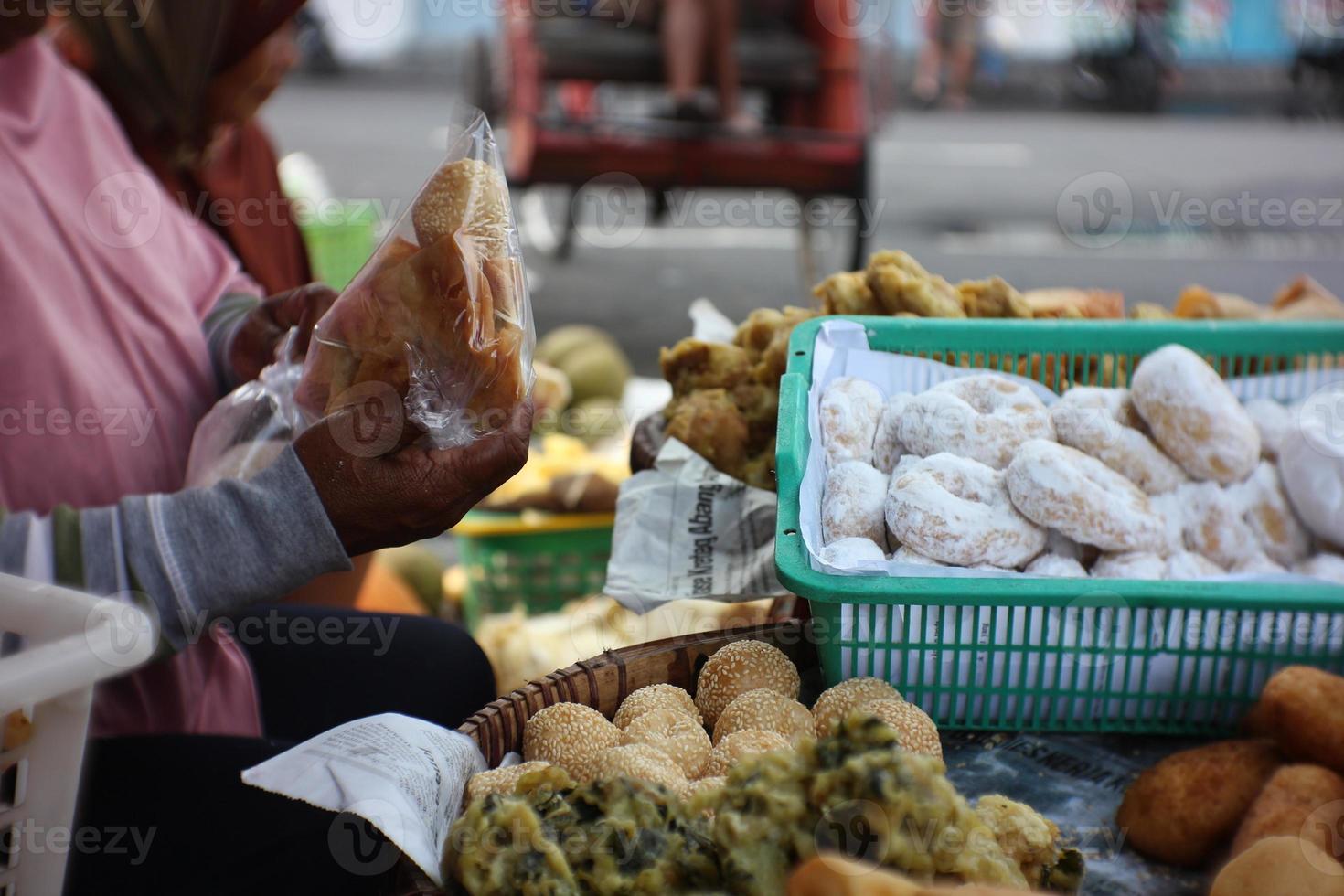 People sell and buy various traditional cakes and various fried foods photo