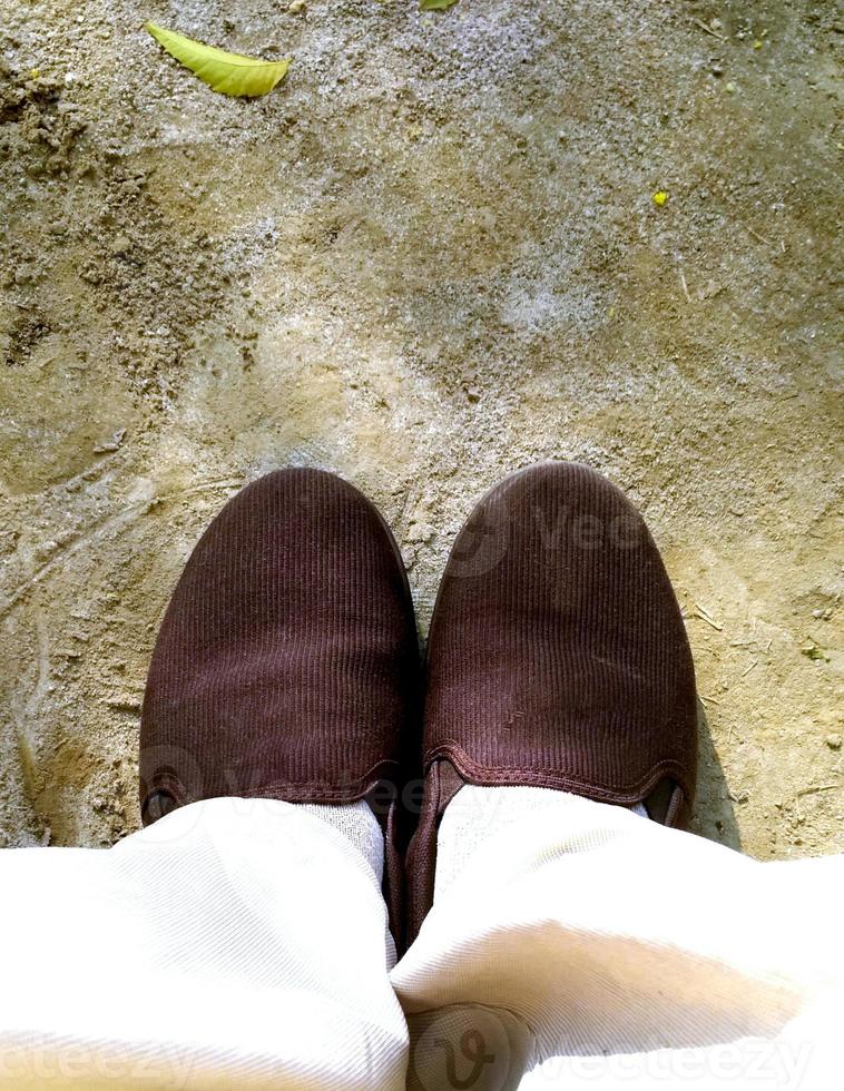 Top view of a pair of brown sneakers shoes on concrete floor background. photo