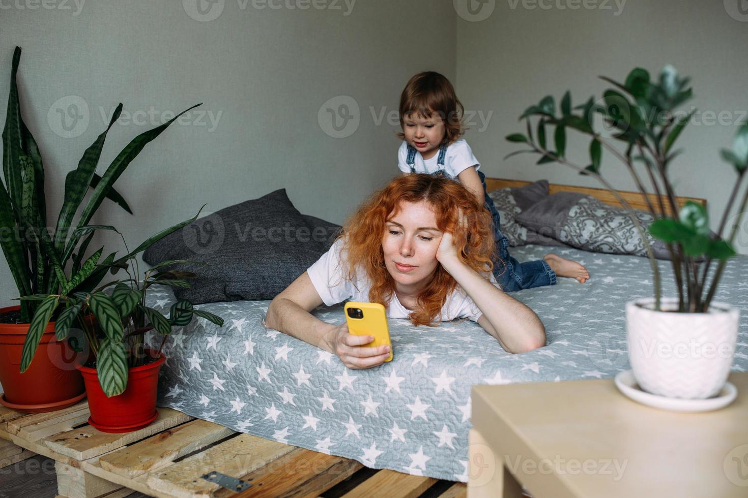 la joven madre y el niño toman fotos juntos en casa, se divierten