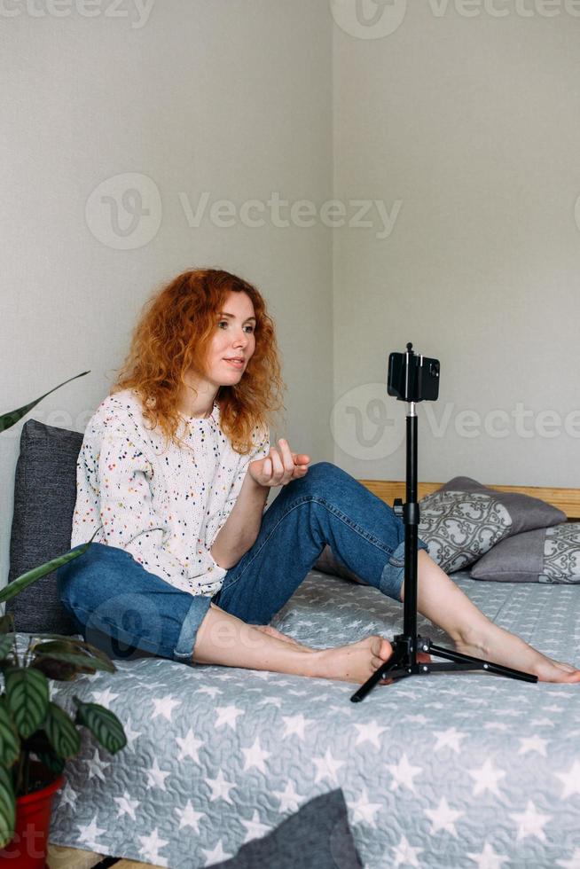 Blogger woman writing wide video blog, looking at smartphone photo