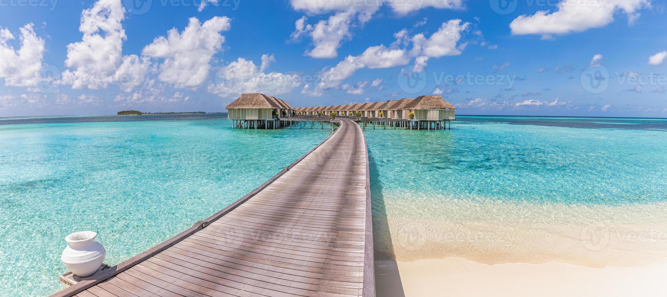 hermosa villa de agua de maldivas en laguna azul y espacio de cielo azul. paisaje panorámico de verano, laguna oceánica con un relajante cielo azul nublado idílico. antecedentes de viajes de lujo exóticos. Increíble vista de Maldivas foto