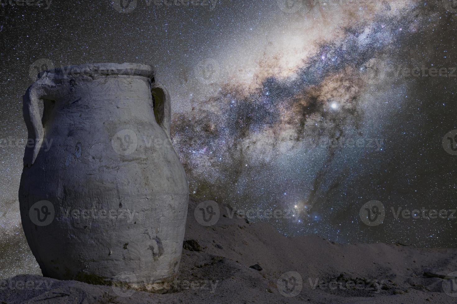 ánfora antigua contra el fondo del cielo nocturno con la vía láctea, el espacio exterior. el concepto de astronomía y arqueología. cartel, educación foto