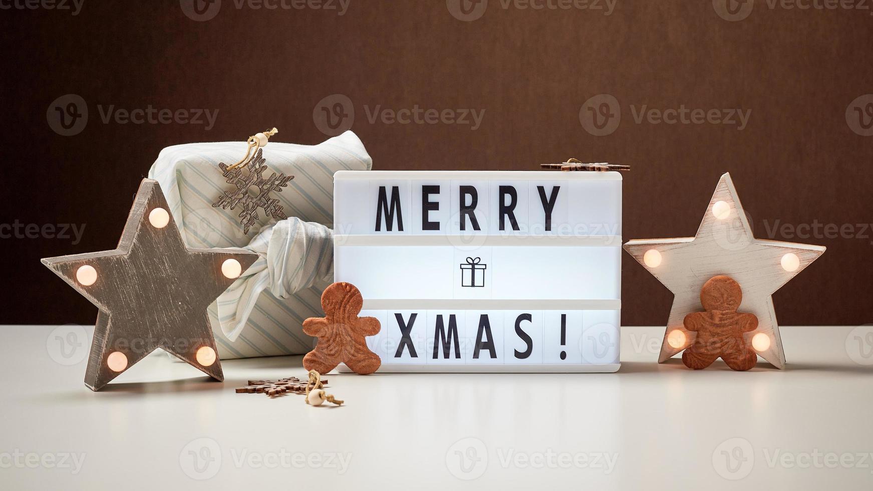 caja de luz inscripción feliz navidad y adornos de madera foto