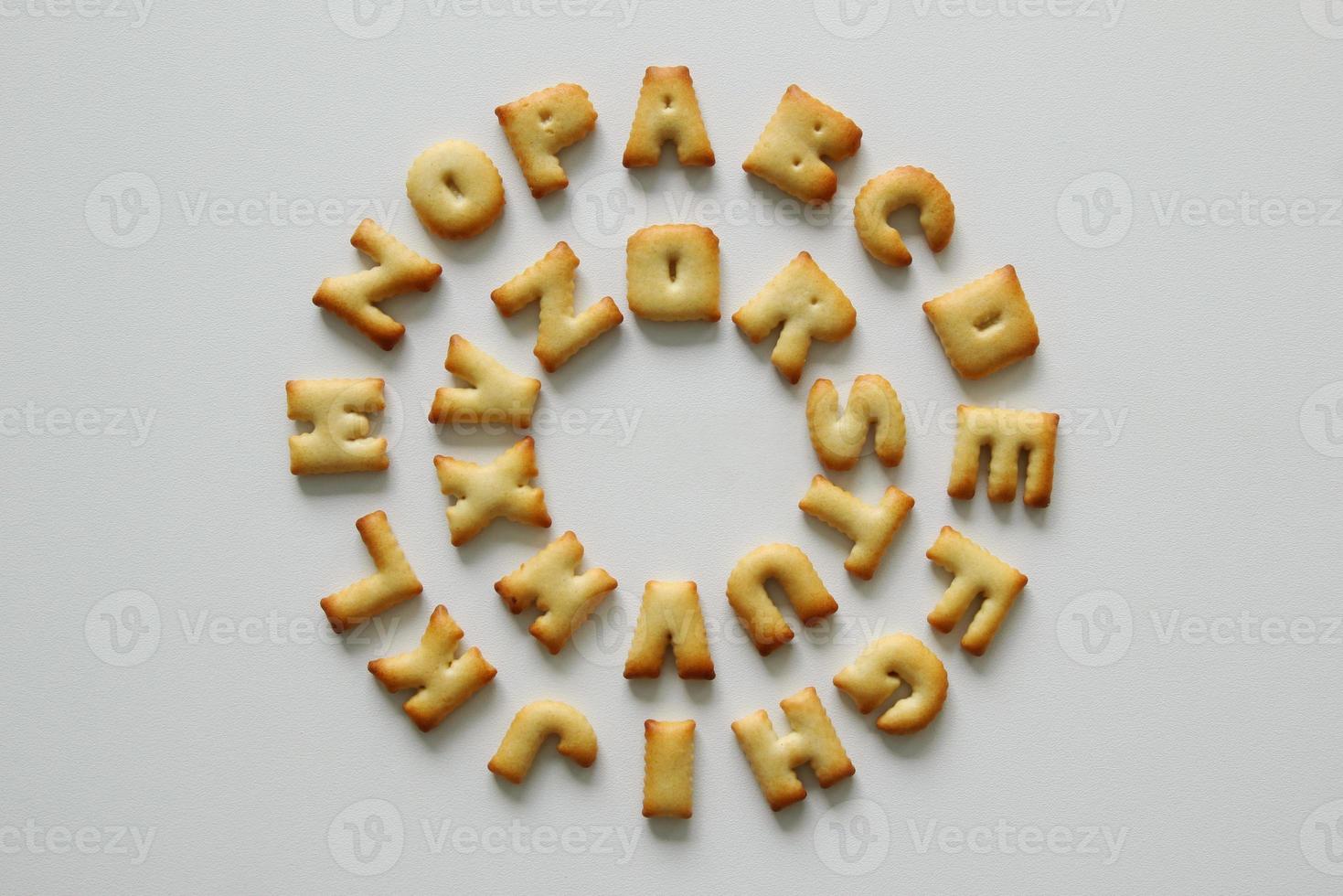 An English alphabet from the cookies in a circle on the white background. photo
