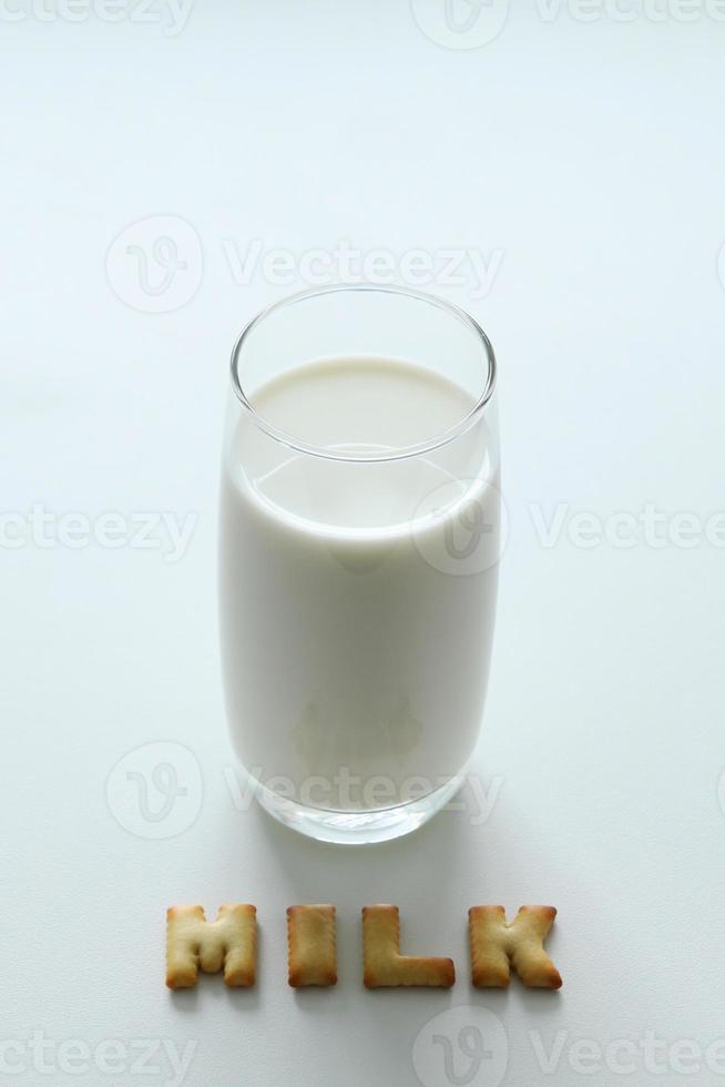 A glass of milk with inscription from the cookies on the white background. photo