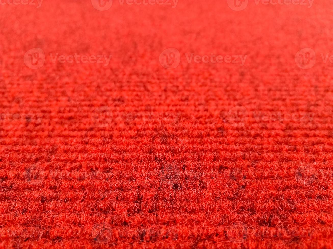 Red woolen carpet background with perspective view, selective focus photo