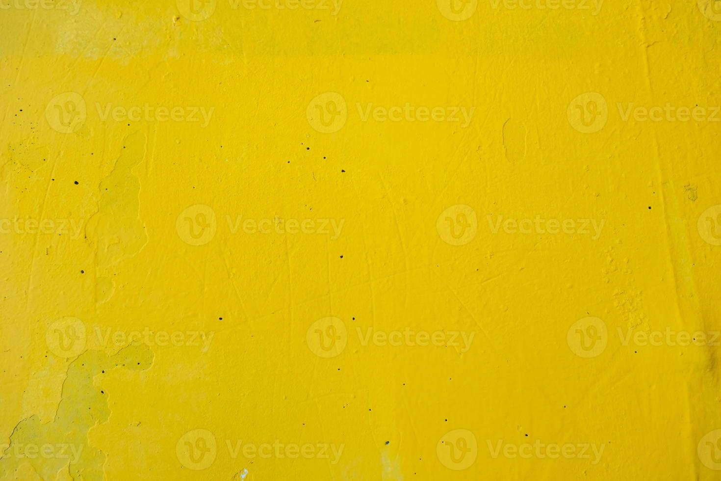 old wall painted with yellow paint with cracks and bubbles photo