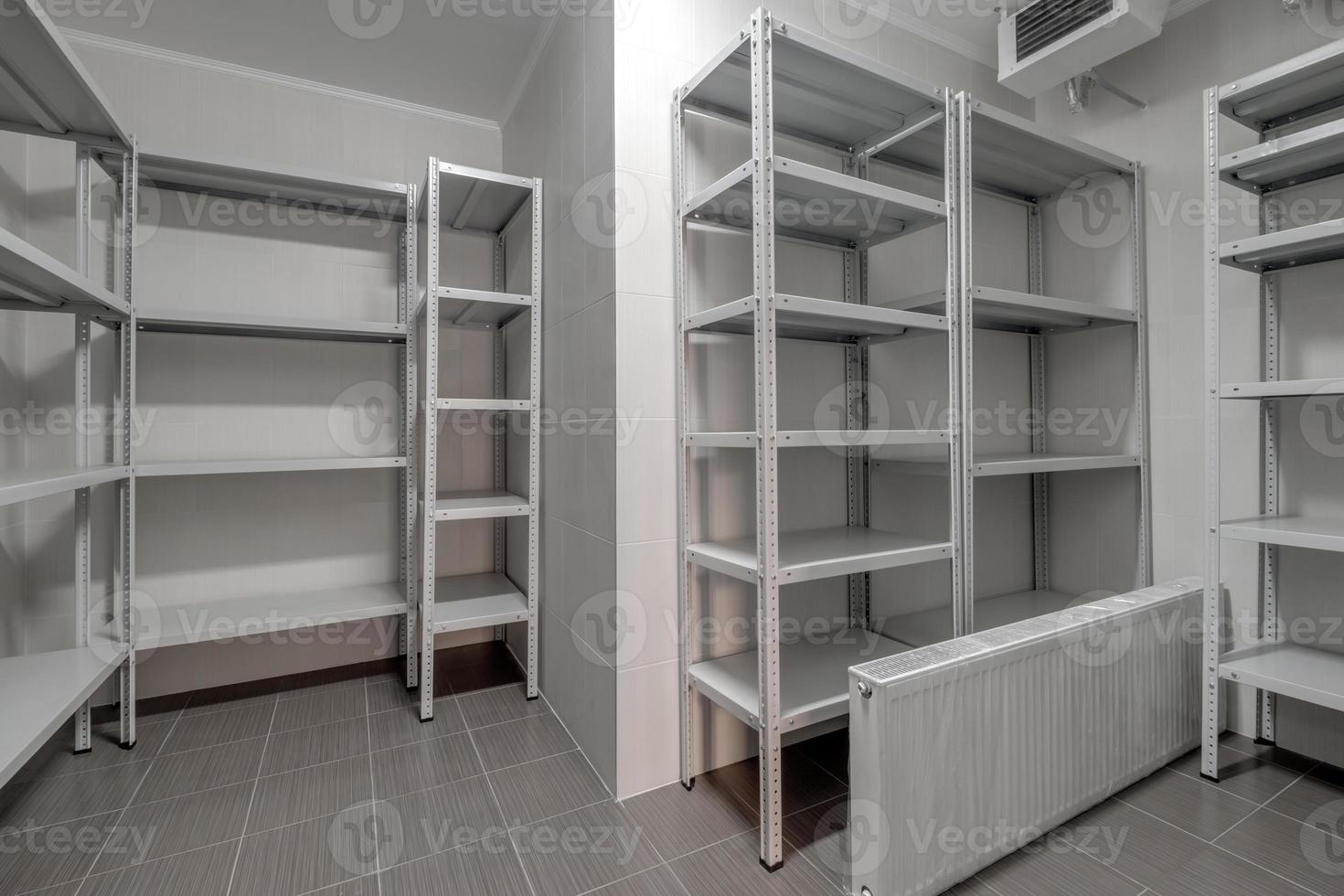 rows of metal shelves in fridge wardrobe. refrigerator for storing large amounts of food photo