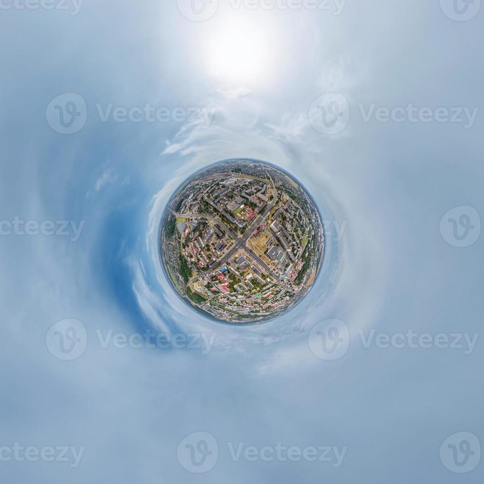 tiny planet in sky with clouds overlooking old town, urban development, historic buildings and crossroads. Transformation of spherical 360 panorama in abstract aerial view. photo