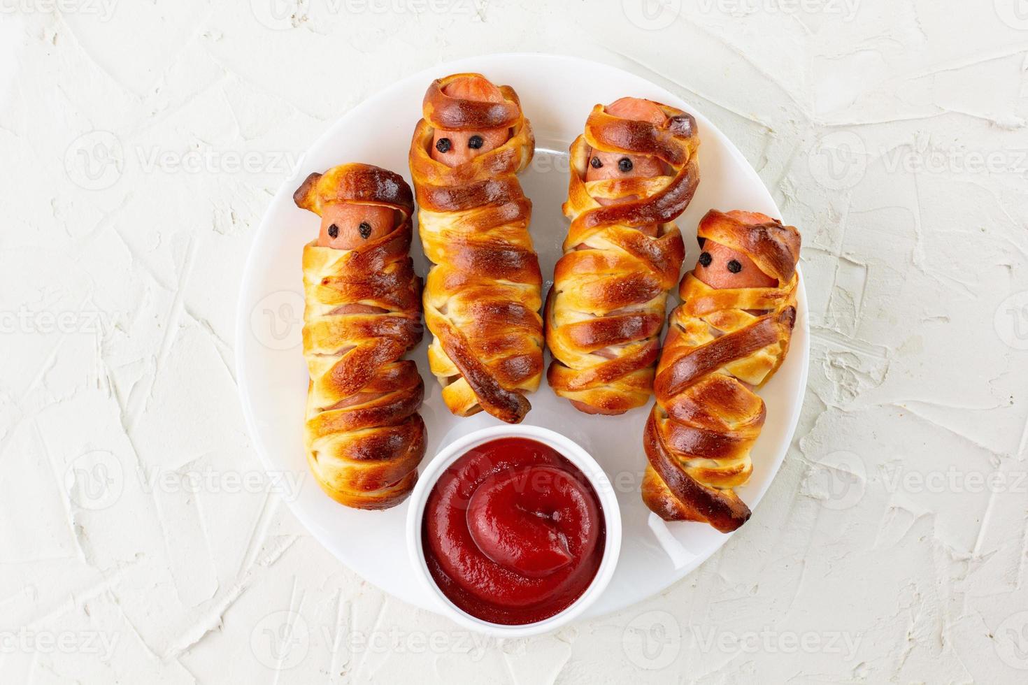 Scary sausage mummies in dough for kids party. Funny crazy Halloween food for children. photo