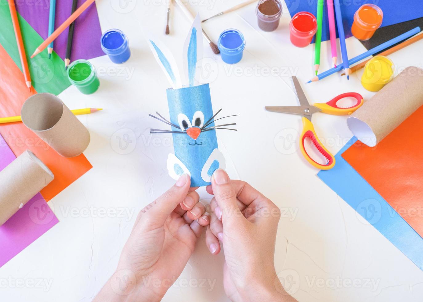 step 4. DIY paper rabbit from a roll of toilet paper. Easy craft for kids on white background, simple DIY idea from toilet tube, recycling concept. Gift ideas, decor for spring, Easter. Step by step. photo