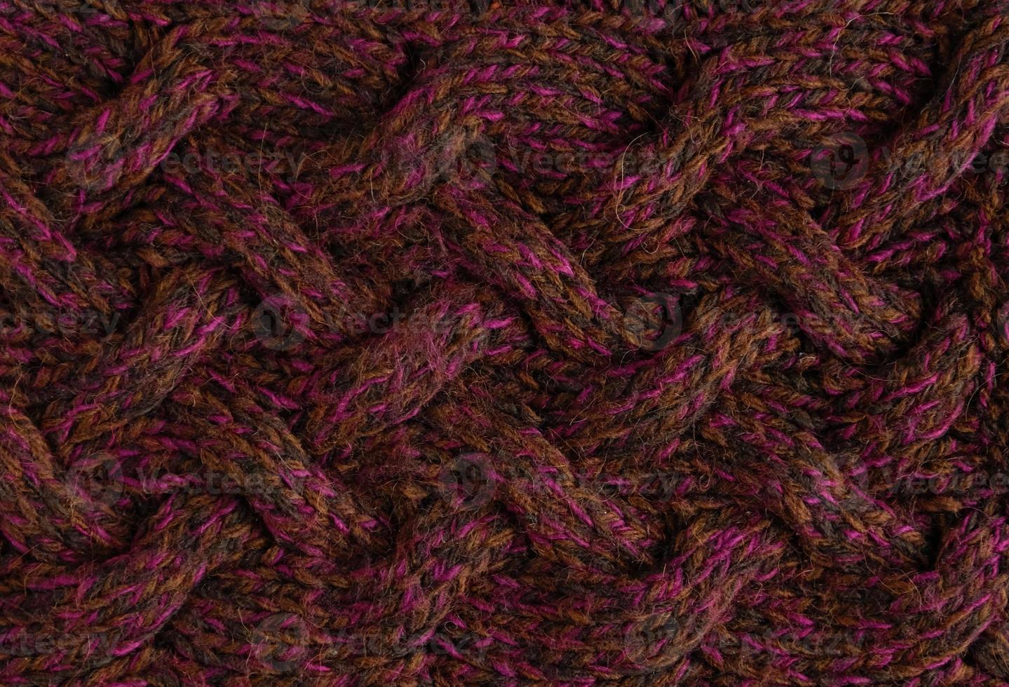 Texture of smooth knitted dark sweater with pattern. Top view, close-up. Handmade knitting wool or cotton fabric texture. Background of knitting patterns with a vertical large Braid Cable. photo