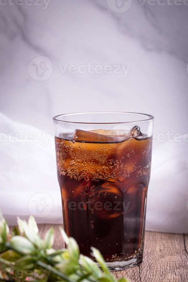 cola cola drink with ice in glass put on wooden background photo