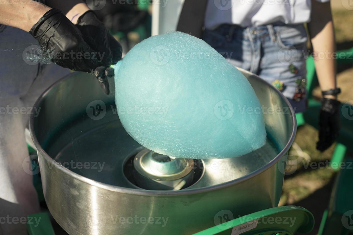 Cotton candy outside. Blue cotton candy on stick. Sugar product. Delicious food. photo