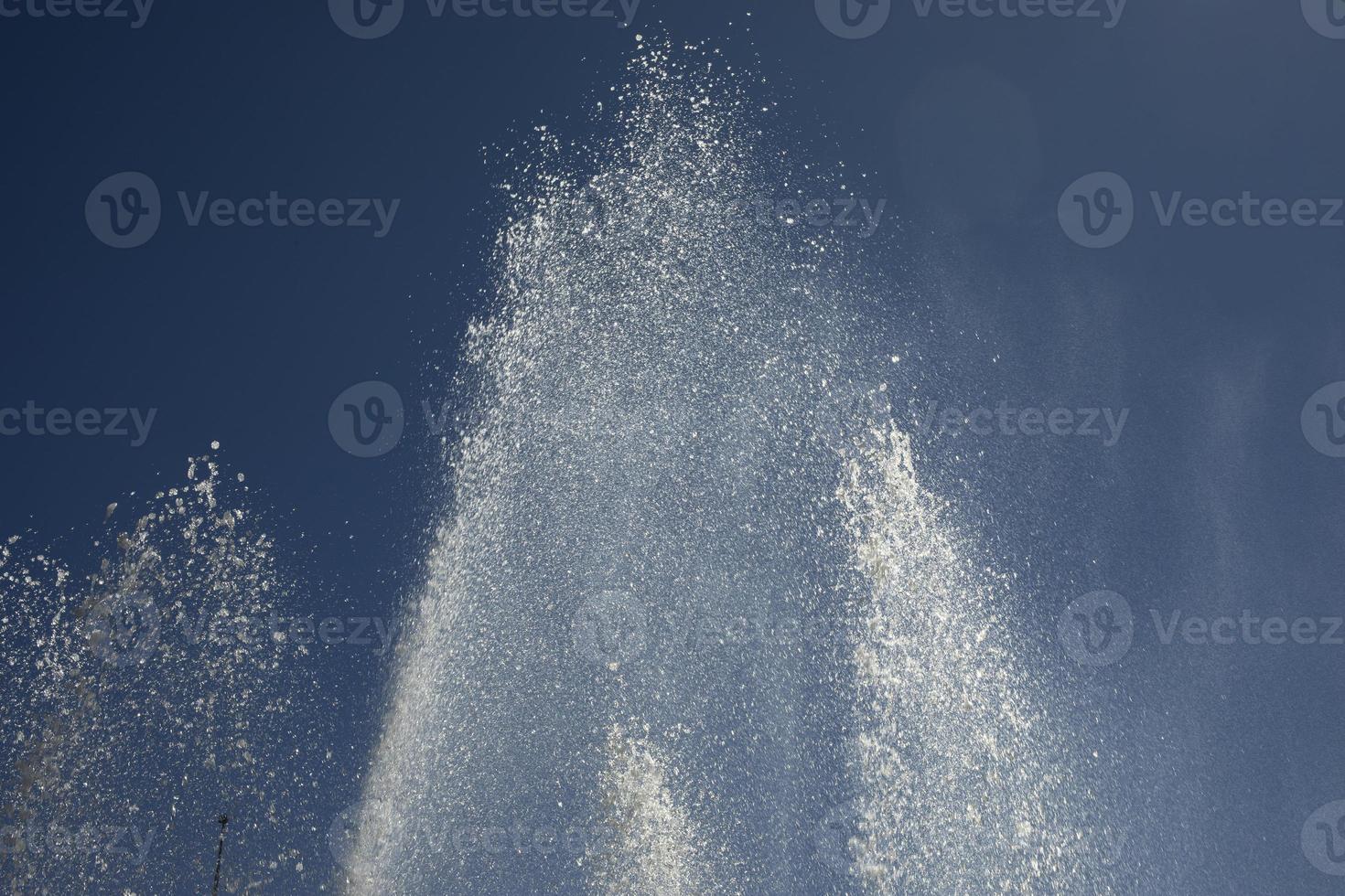 Jets of water against sky. Fountain in city. Details of fountain on street. photo