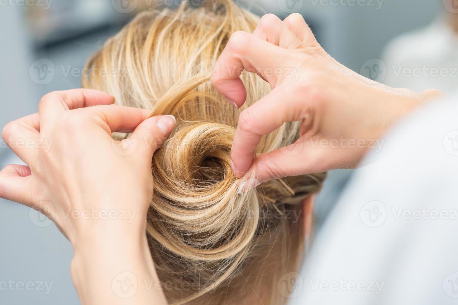 Hairstylist making bride wedding hairstyle photo