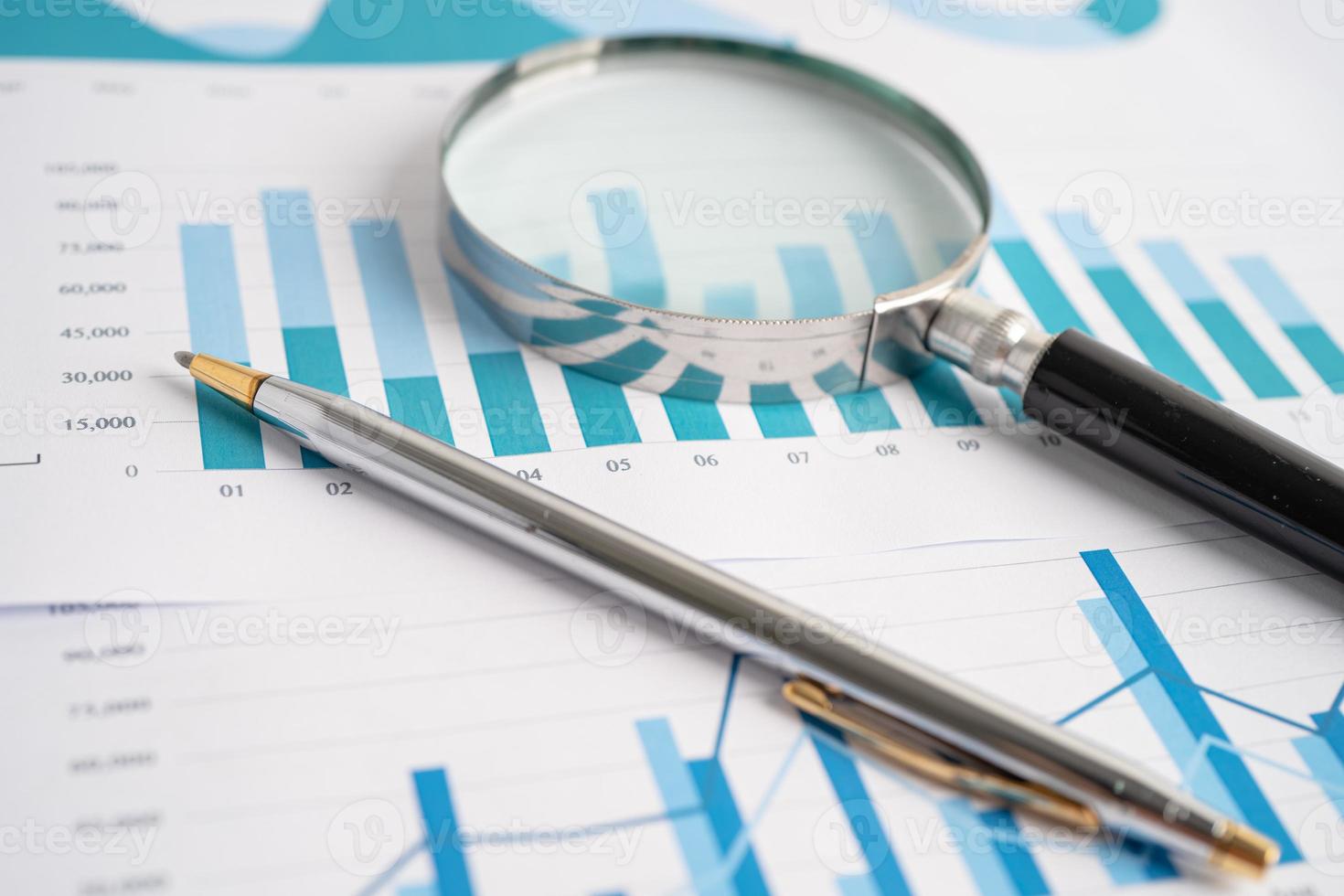 Magnifying glass on charts graphs paper. Financial development, Banking Account, Statistics, Investment Analytic research data economy, Stock exchange trading, Business office company meeting concept. photo