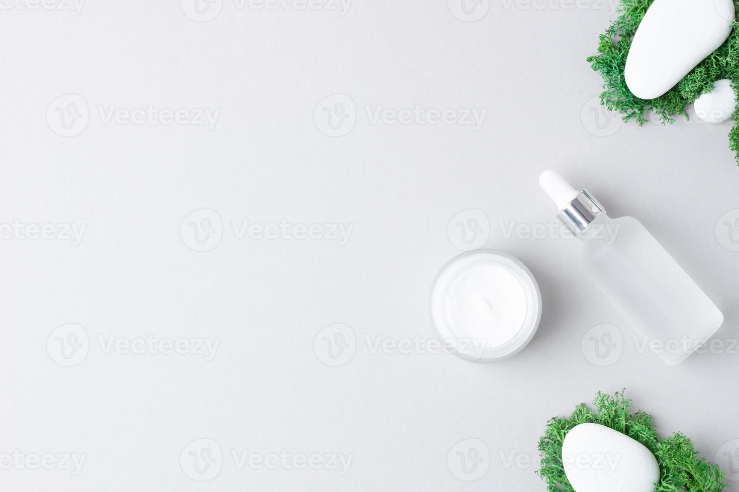 productos cosméticos para el cuidado de la piel con piedras y musgo sobre fondo gris. endecha plana, espacio de copia foto