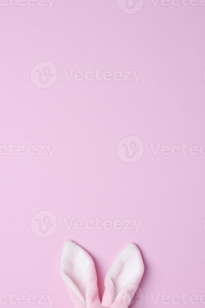 Bunny ears on pink background. Flat lay, copy space photo