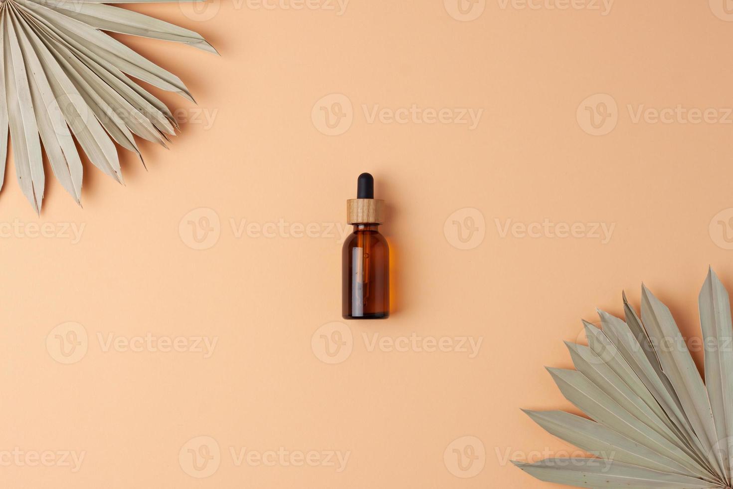 Cosmetic bottle on beige background with tropical. Flat lay. photo