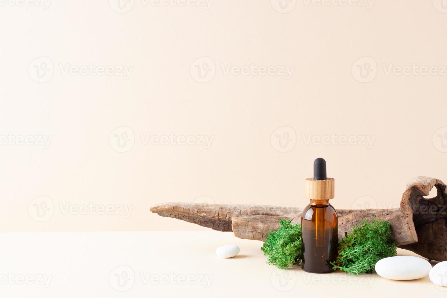 Cosmetic bottle with stones and moss on pastel beige background. Close up, copy space photo