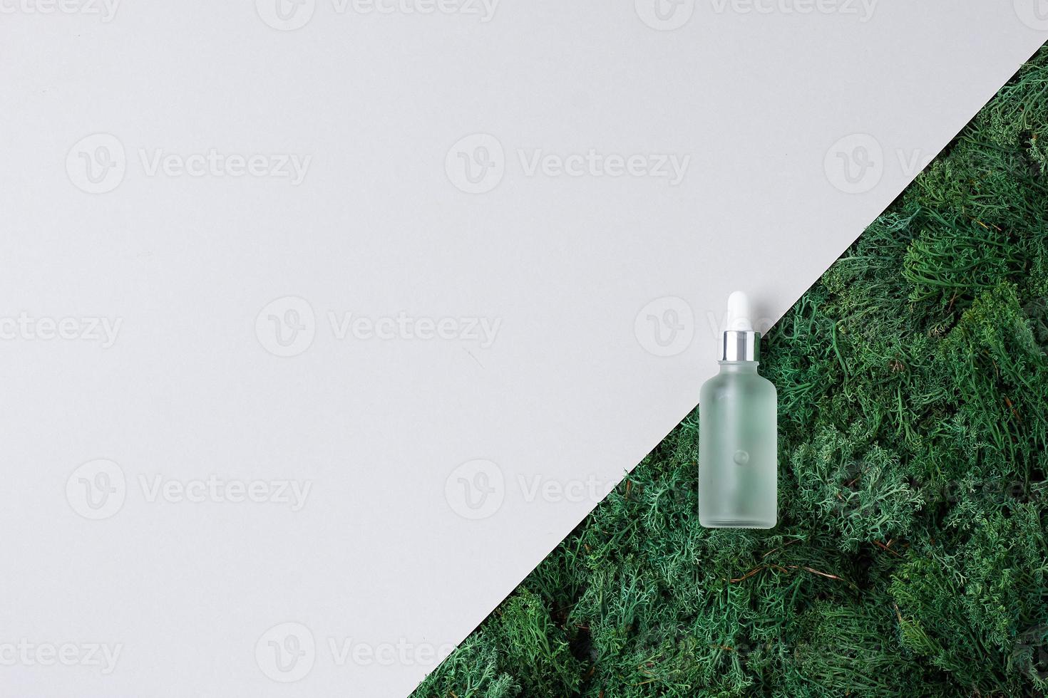 Cosmetic bottle with moss on white background. Flat lay, copy space. photo