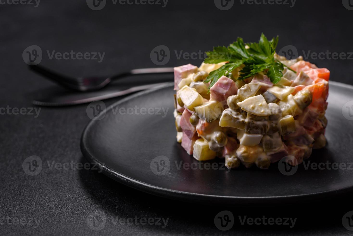 Delicious fresh Olivier salad with sausage, egg, cucumber, green peas, carrots and mayonnaise photo