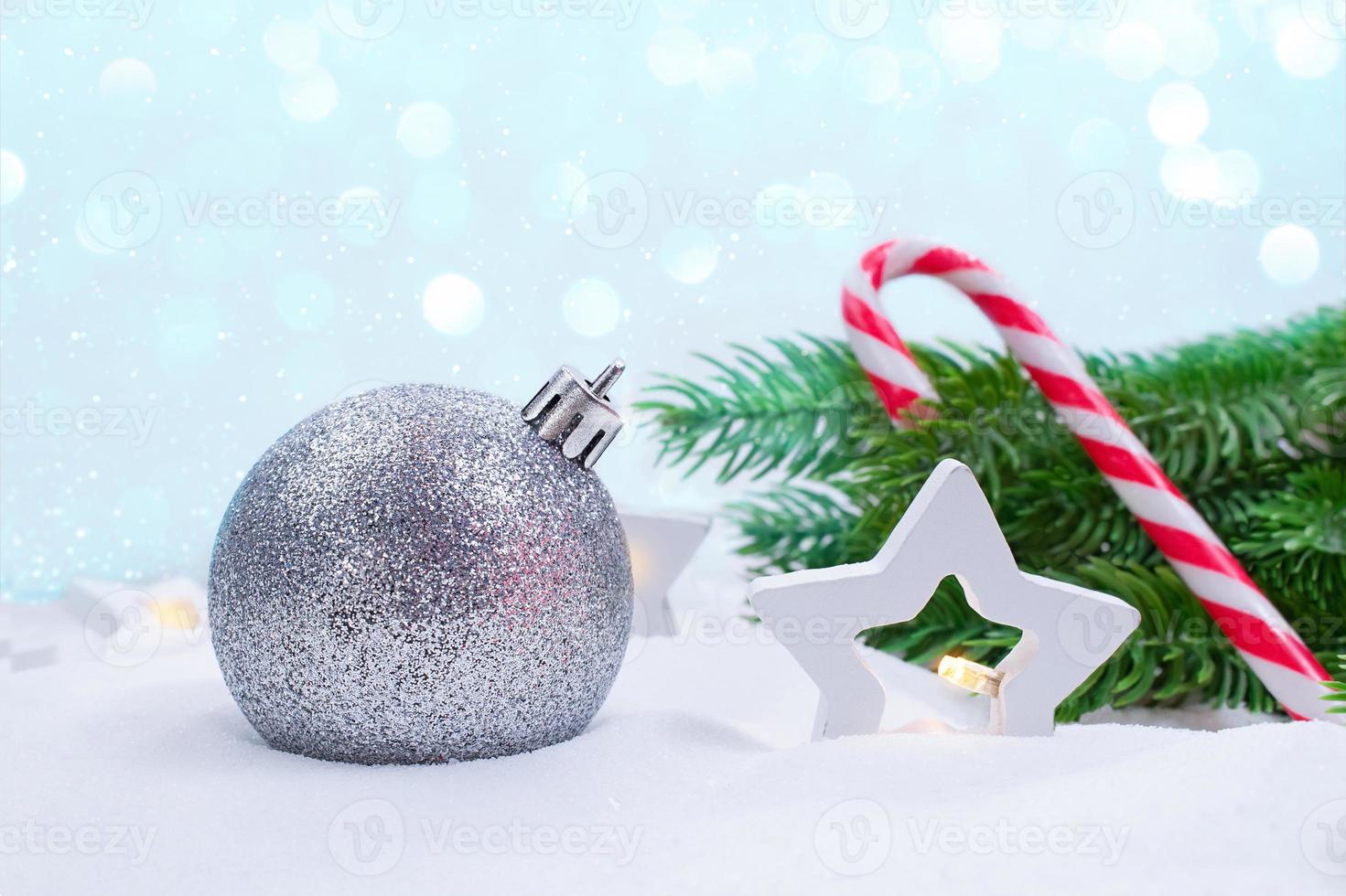 Silver ball, stars lanterns, fir branches and candy cane on snow. Soft focus. Concept of Christmas, New Year. Copy space photo