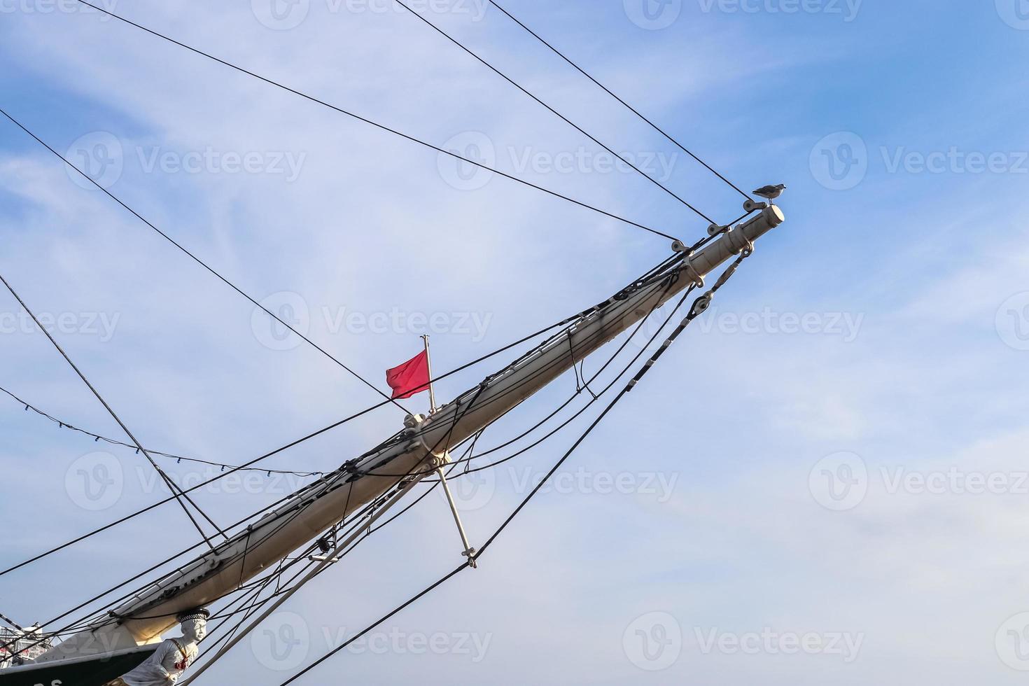 Sailing ship mast against the blue sky on some sailing boats with rigging details. photo
