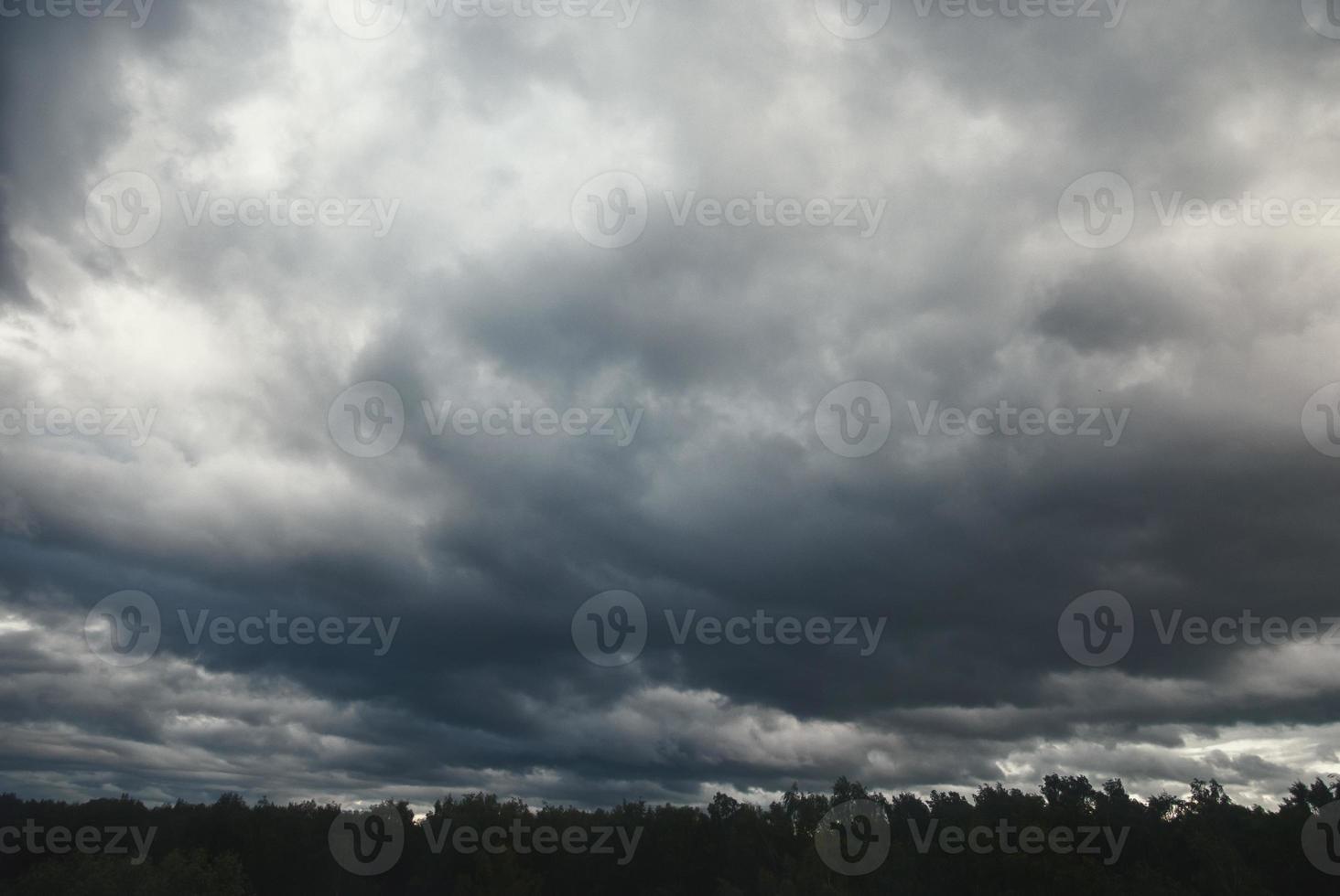 pesadas nubes bajas oscuras sobre el bosque antes de la tormenta foto