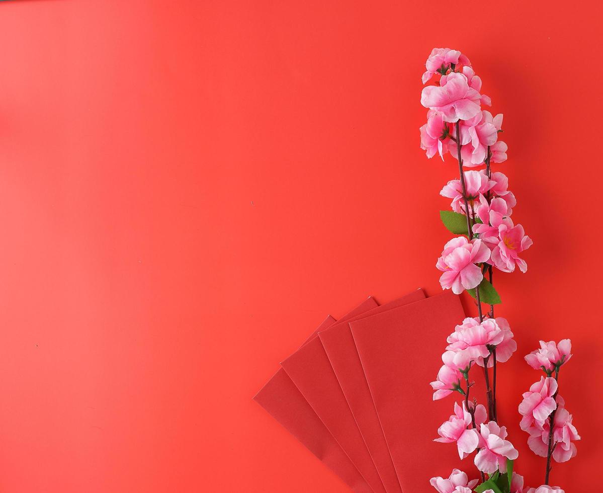 Top view envelope and flower on red background for chinese new year festival photo