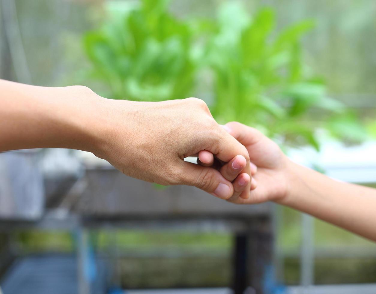 Mother hold child hand for helping , recure and walk together photo