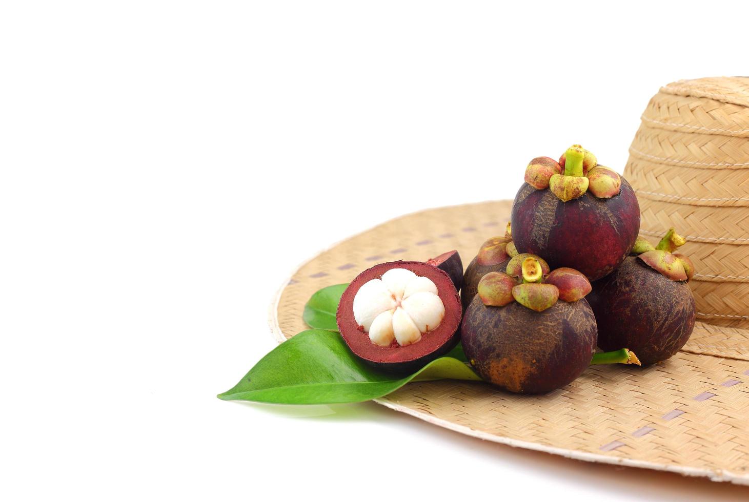 Group of mangosteens with it leaves on weaven hat photo