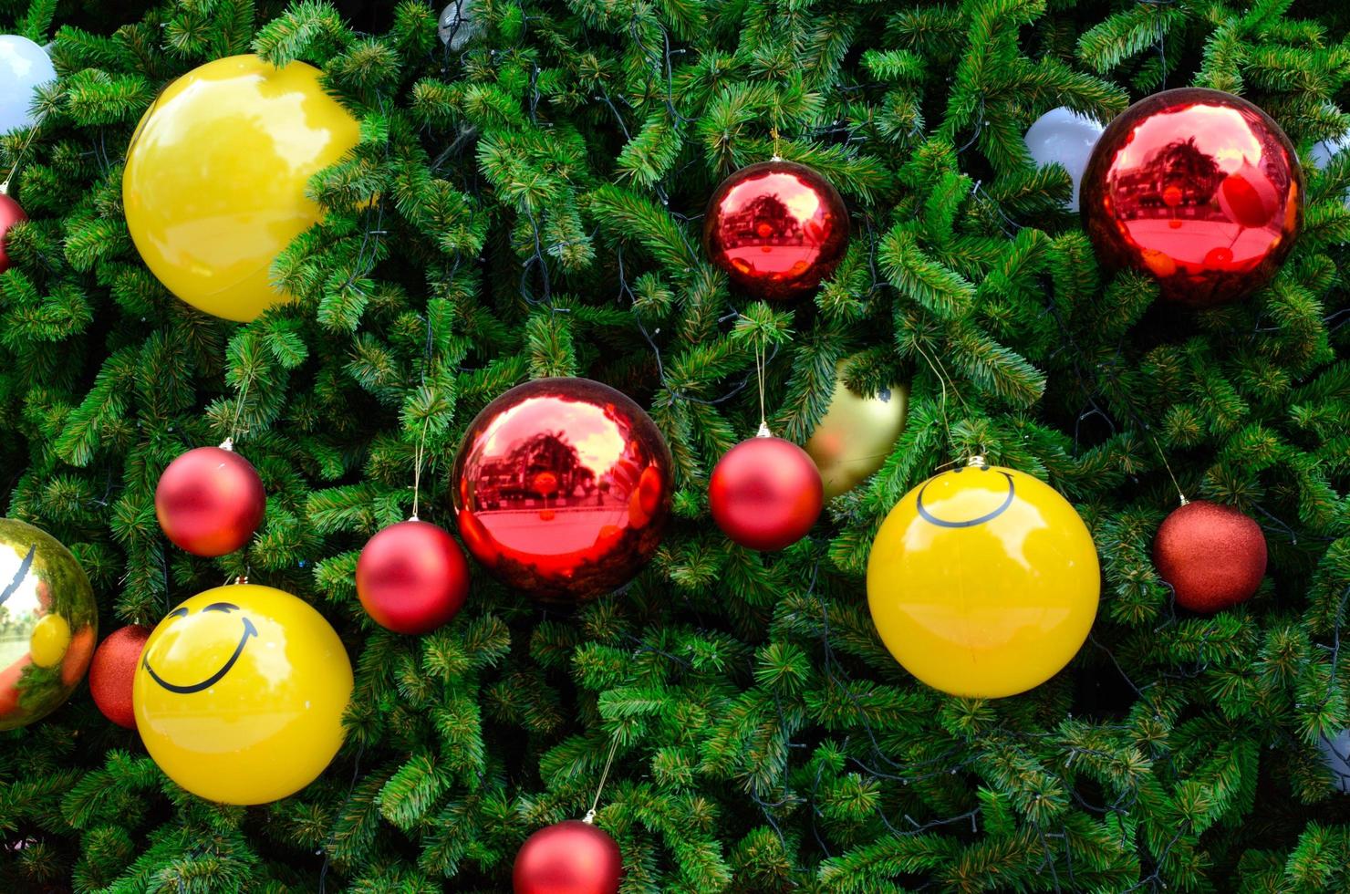 Christmas tree decorates with red, gold and smiling yellow baubles for Christmas holiday photo