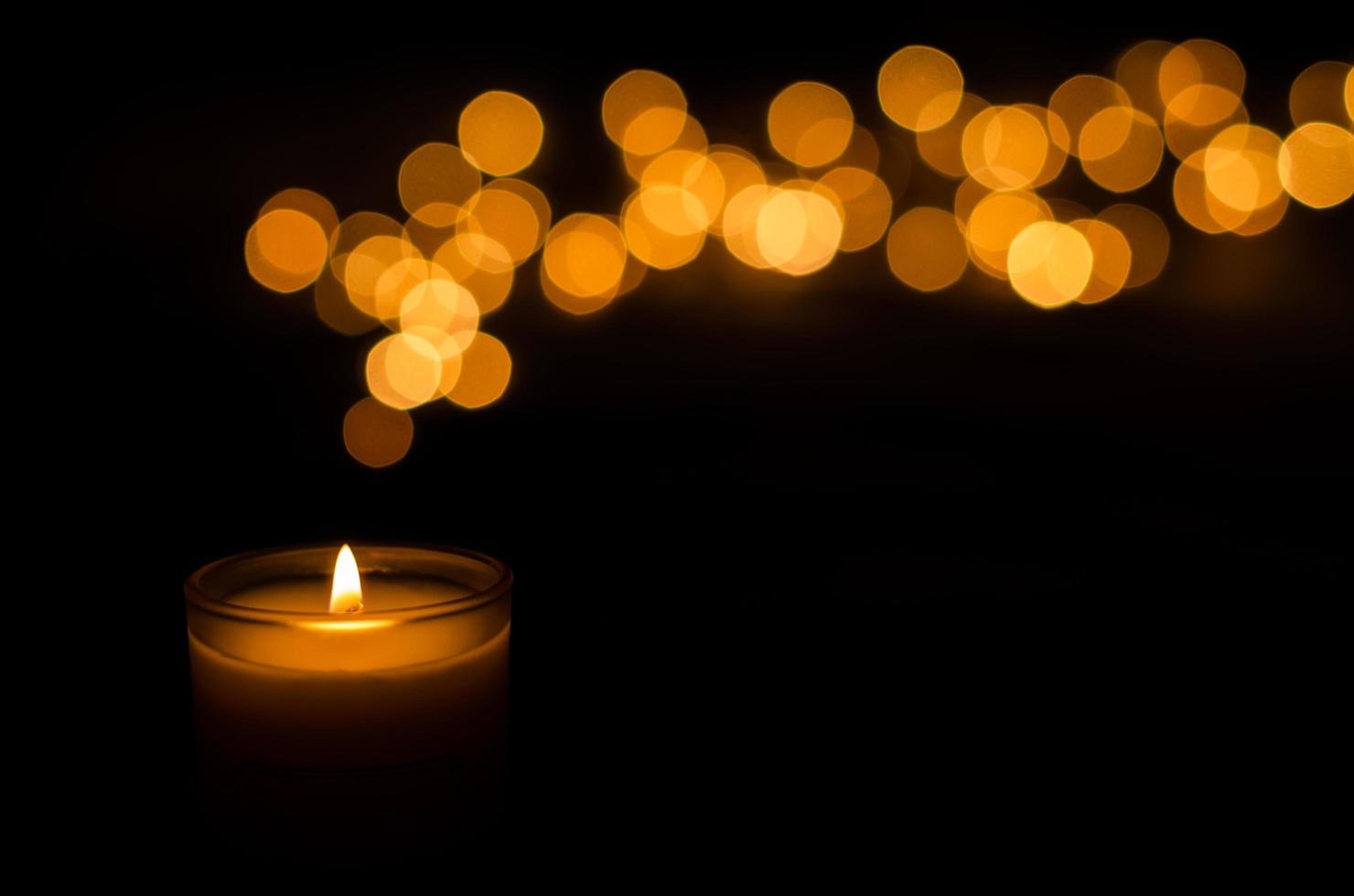 Aromatic candle with flame and round shape bokeh on dark background for Thanks giving and Christmas day. photo