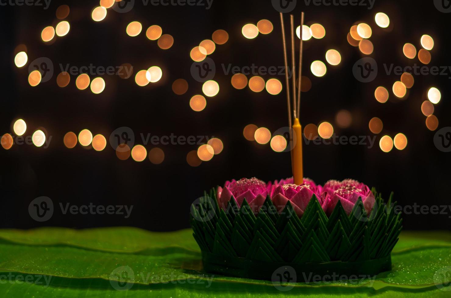 Banana leaf Krathong with 3 incense sticks and candle decorates with pink lotus flower for Thailand Full moon or Loy Krathong festival. photo