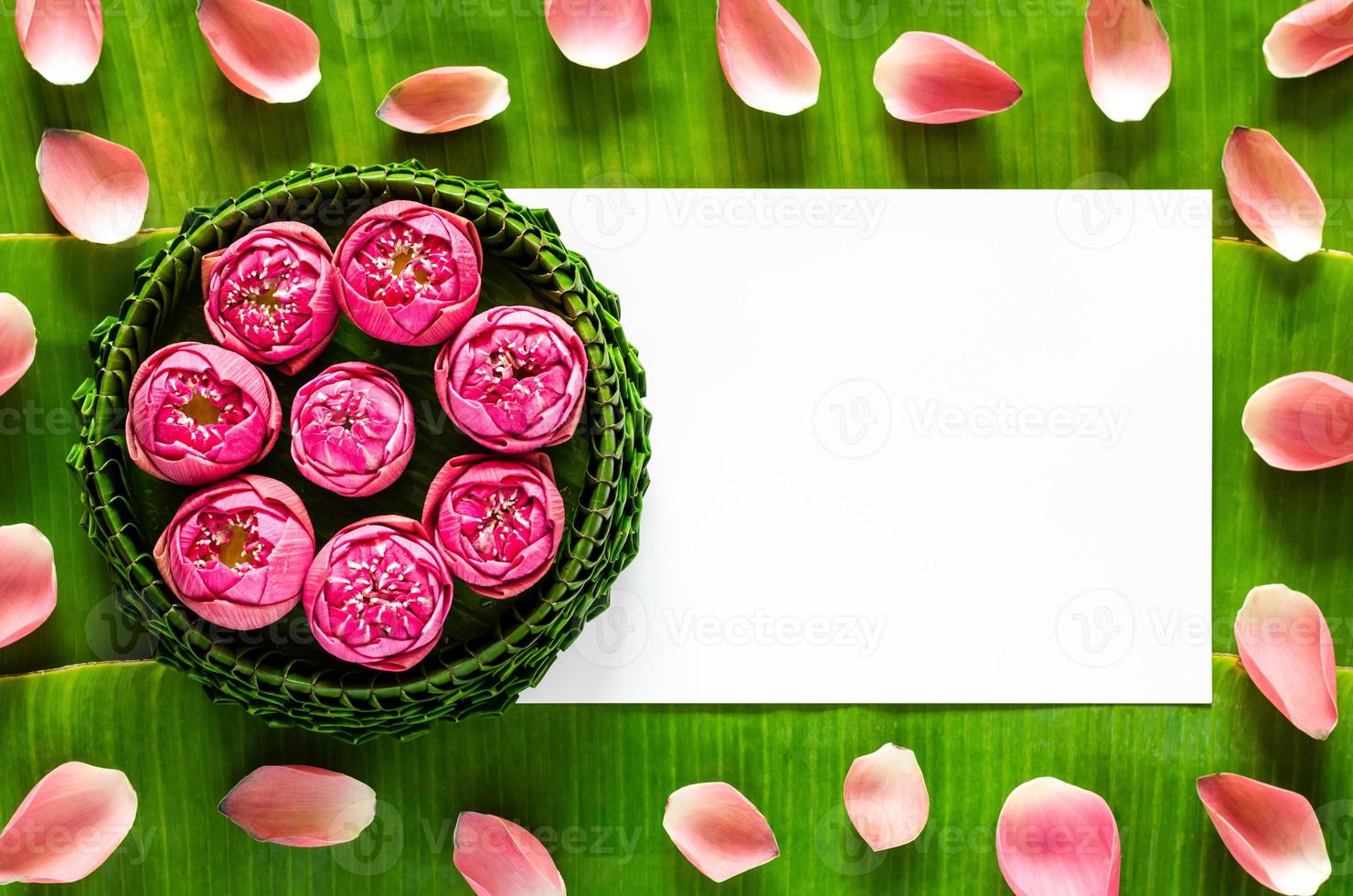 krathong de hoja de plátano para el festival de luna llena o loy krathong de tailandia con espacio para texto sobre hojas de plátano y fondo de pétalos de loto. foto